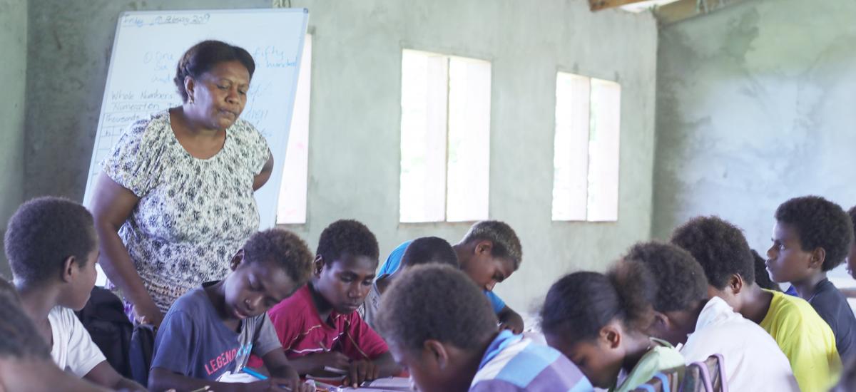 Teacher supervises students in a Vanuatu primary school.