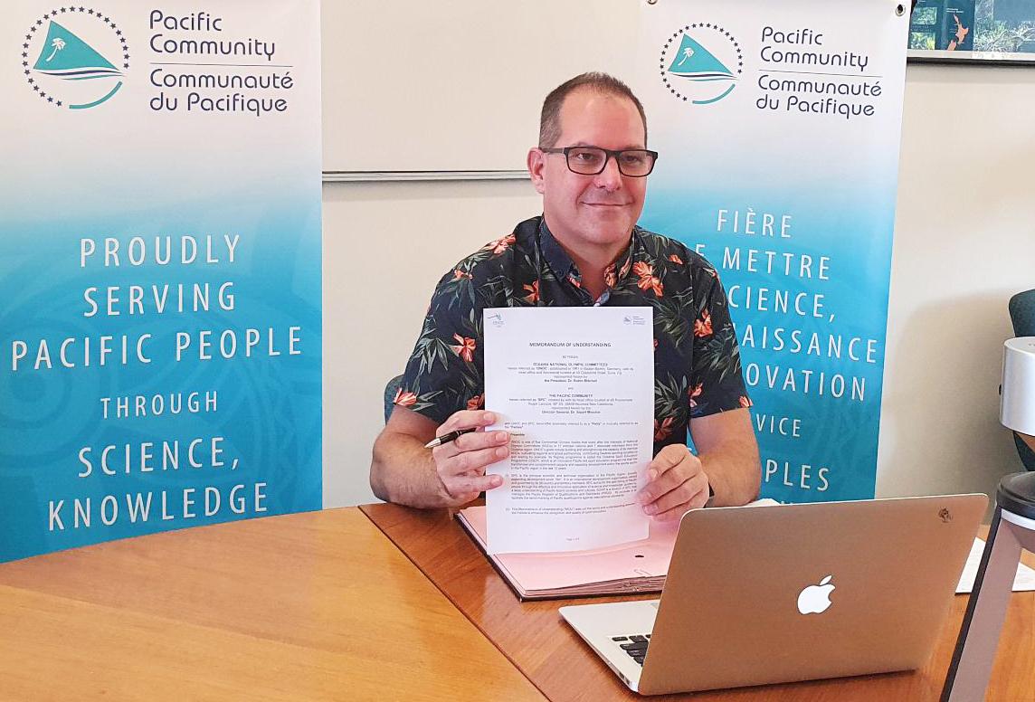 SPC Director-General Dr Stuart Minchin proudly shows the signed SPC-ONOC agreement from the SPC headquarters in Noumea. 