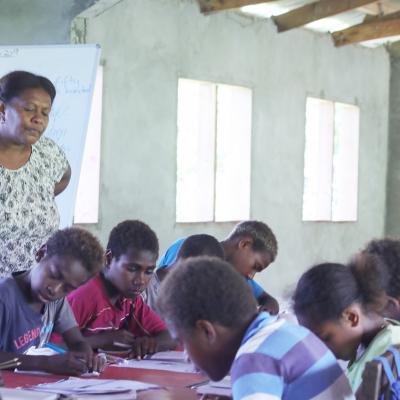 Teacher supervises students in a Vanuatu primary school.